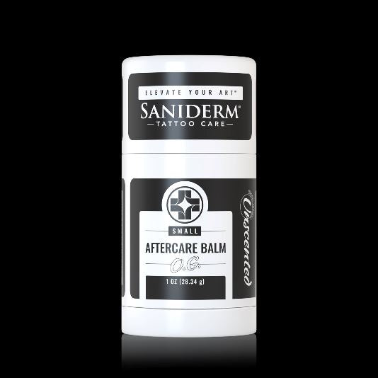 A white cylindrical container of Saniderm Small Aftercare Balm with black and white labels, centered against a solid black background.